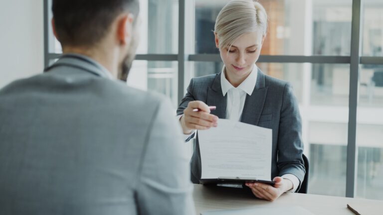 Woman in suit shows document to man